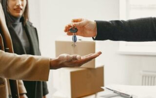 Person Giving Keys from New Home to Family