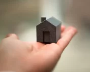 hand holding small black model house