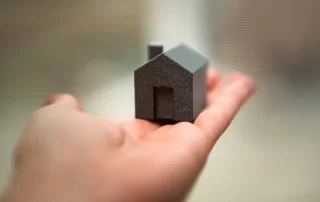 hand holding small black model house