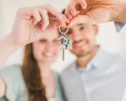 couple proudly holding up key to new home