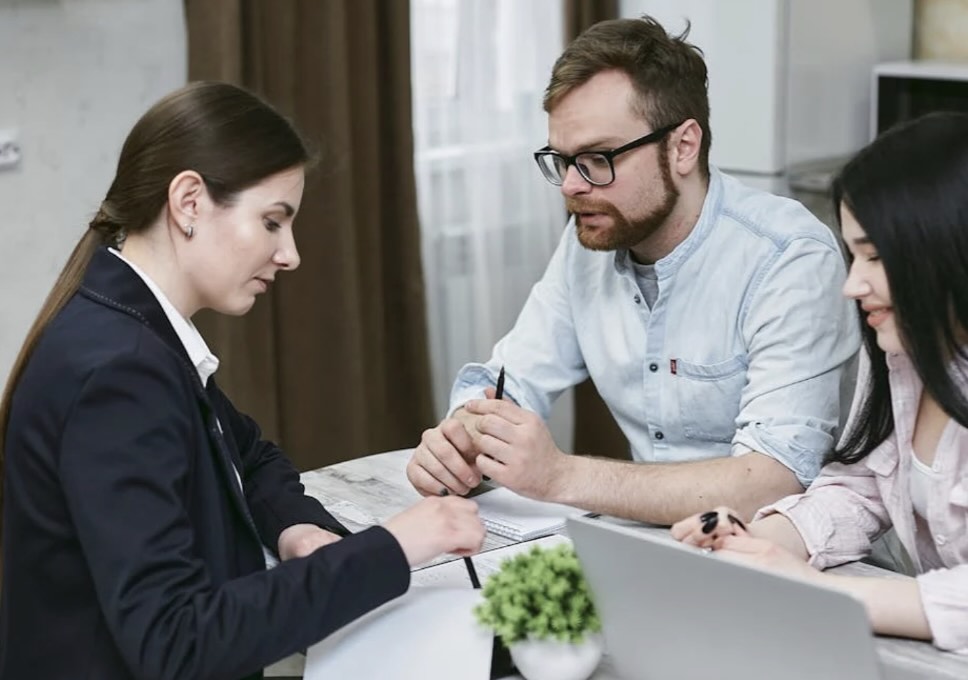 Couple going over paperwork with a business woman