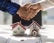 People shaking hands after the signing of a house contract agreement is complete